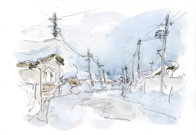 雪に埋もれる民家。こんな時は道の前後の電柱が、道しるべとなっている。